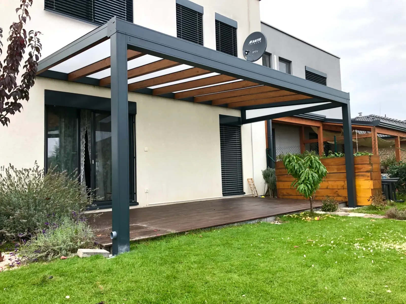 Hliníková pergola s dřevěnou střechou u rodinného domu – realizace Flowgarden